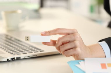 Bilgisayarlı bir iş kadını ofiste flaş bellek gösteriyor.