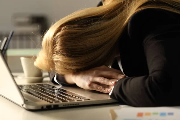 オフィスで夜に机の上でノートパソコンの上で寝て疲れて過労したビジネスの女性の終わり — ストック写真