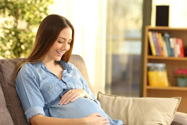 Mujer Embarazada Feliz Esperando Mirando Vientre Sentado Sofá Sala Estar — Foto de Stock
