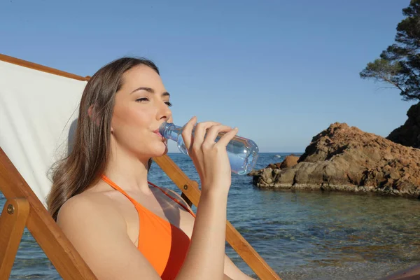 Bere Acqua Bottiglia Seduti Una Sedia Sdraio Sulla Spiaggia — Foto Stock