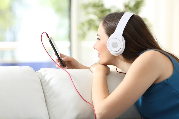 Chica Escuchando Música Con Auriculares Teléfono Inteligente Sofá Casa — Foto de Stock