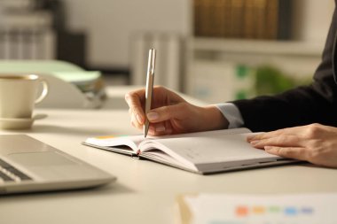 Akşamları masa başına yazı yazan yönetici kadın ellerini kapat.