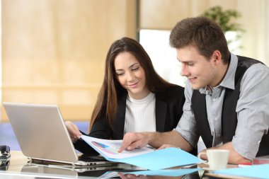 Kağıt belgelerinin istatistiklerini kontrol eden ciddi ofis çalışanları