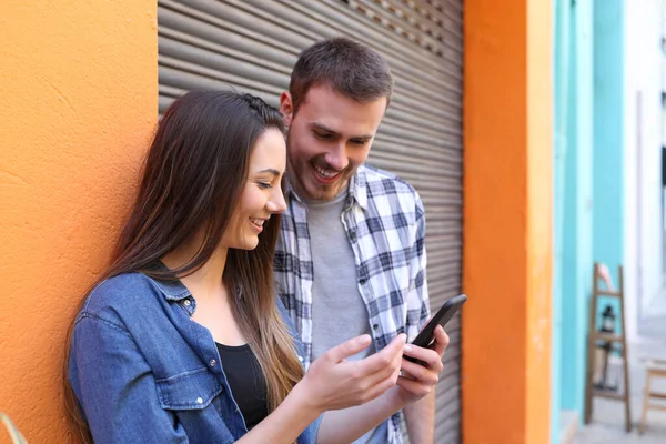 Pareja Feliz Hablando Contenido Teléfonos Inteligentes Una Calle Colorida — Foto de Stock