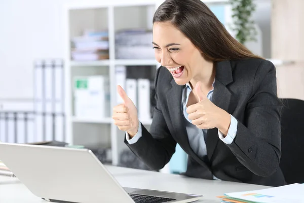 幸せなエグゼクティブ女性ともに親指アップビデオコール上のラップトップ座っています彼女の机の上にオフィス — ストック写真