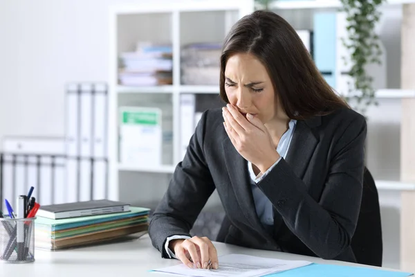 事務所の机の上に座っているYawning疲れ過労の幹部女性 — ストック写真