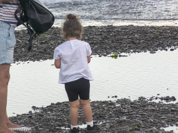 Little girl on the sea beach plays — Stock Photo, Image