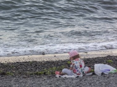 Deniz kıyısındaki küçük kız oynuyor