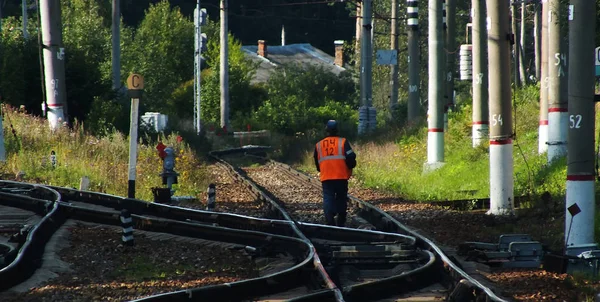 Worker walks along the railroad tracks — 스톡 사진