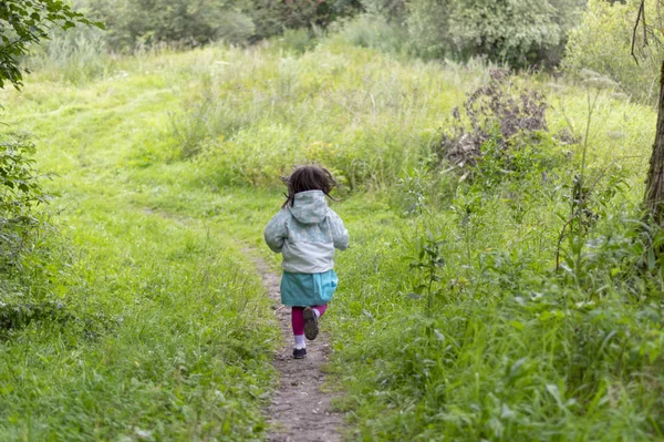 Little girl runs away in forest — Stock Photo, Image