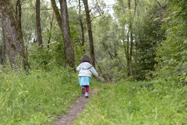 Little girl runs away in forest — Stock Photo, Image