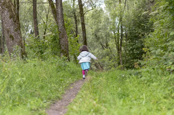 Little girl runs away in forest — Stock Photo, Image