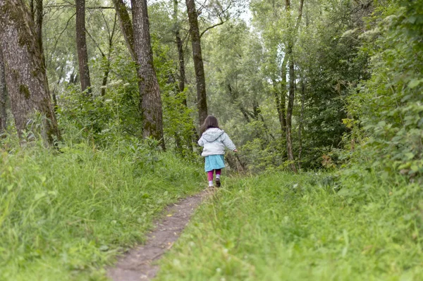 La niña huye en el bosque Imágenes de stock libres de derechos