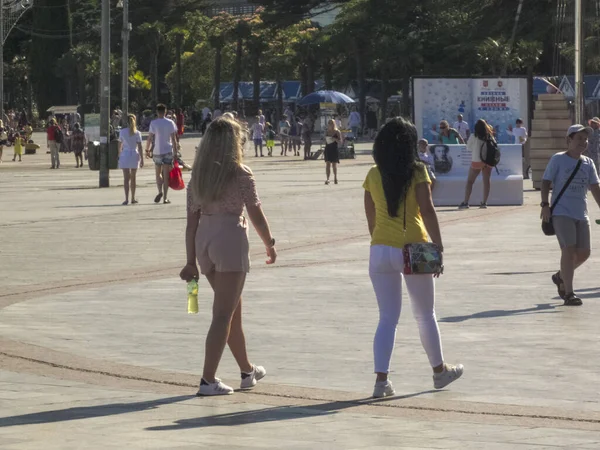 Dziewczyny spacerują wzdłuż promenady miasta w słoneczny dzień — Zdjęcie stockowe