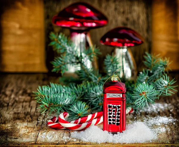 Christmas grannlåt telefonkiosk, champinjoner, candy cane Santa pinnar och fir gren på vintage trä bordet. Jul och nyår sammansättning. — Stockfoto