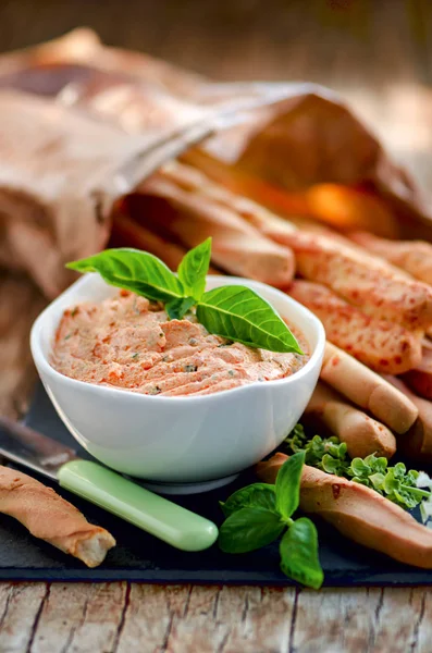 Ricotta met zon gedroogde tomaten en basilicum, grissini met Parmezaanse kaas geserveerd op het leisteen bord op de vintage houten tafel — Stockfoto