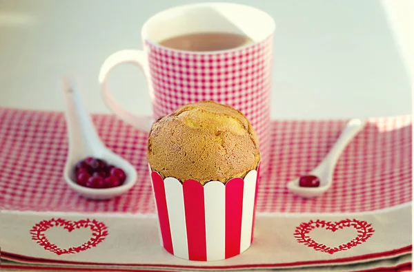 Cupcake, Tee, Preiselbeeren auf dem karierten Muster mit Herzen serviert. — Stockfoto