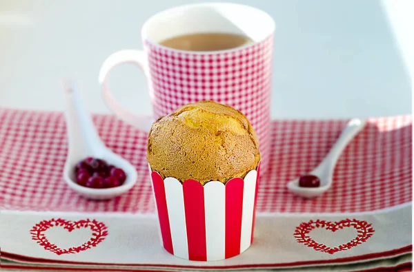 Cupcake, tea, cranberries served on the checkered pattern with hearts. — Stock Photo, Image