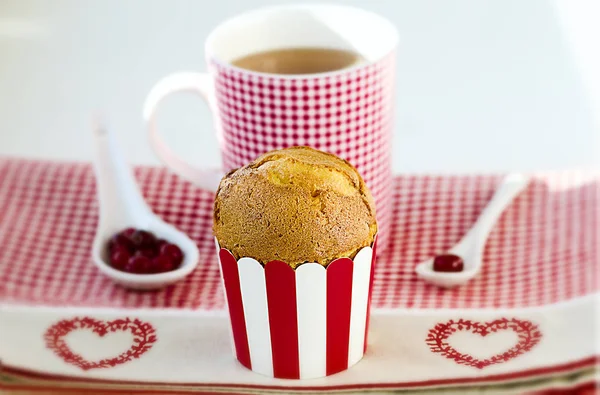 Cupcake, tea, cranberries served on the checkered pattern with hearts. — Stock Photo, Image
