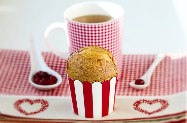 Cupcake, Tee, Preiselbeeren auf dem karierten Muster mit Herzen serviert. — Stockfoto