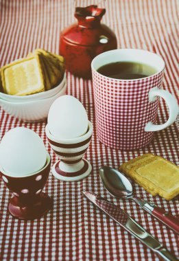 Katı pişmiş yumurta, çay ve kurabiye noktalı, hizmet çizgili ve kareli kırmızı ve beyaz çanak çömlek