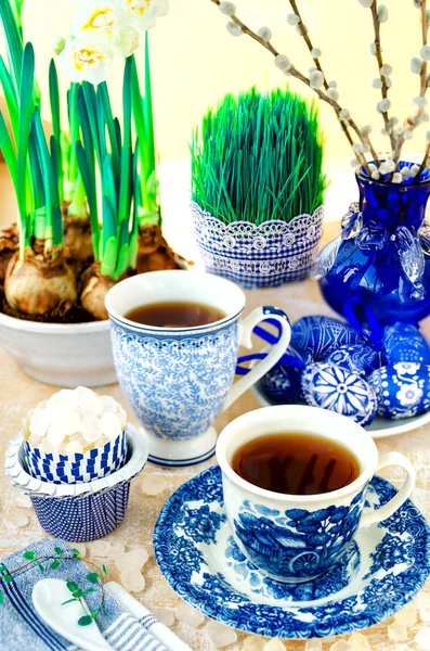 Pasen decoratie met thee, suiker, eieren, narcissen, kut-wilg, mint en kiemen zaden in blauwe kleur — Stockfoto