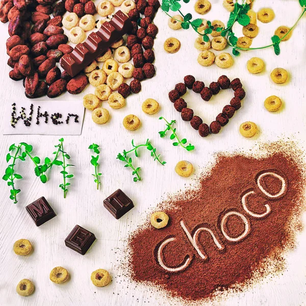 Quando la menta incontra il cioccolato: fave di cacao, barrette di cioccolato, anelli integrali, menta e messaggio "choco" sopra la polvere di cacao . — Foto Stock