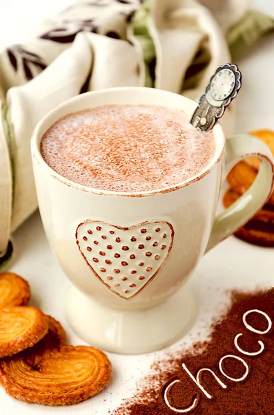 Heißer Kakao mit Sahne, herzförmigem Blätterteig und Schriftzug "Choco" über Kakaopulver — Stockfoto