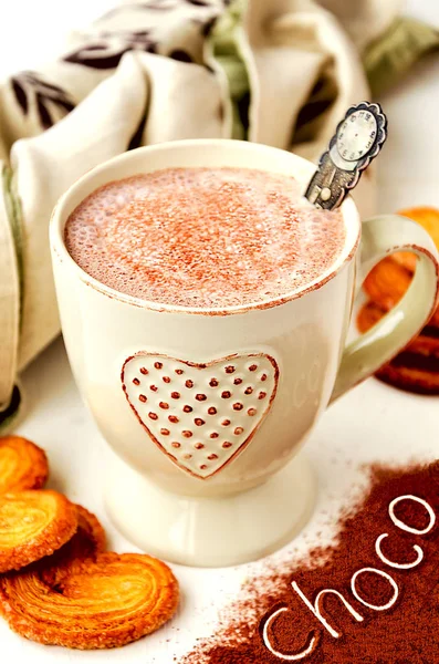 Heißer Kakao mit Sahne, herzförmigem Blätterteig und Schriftzug "Choco" über Kakaopulver — Stockfoto