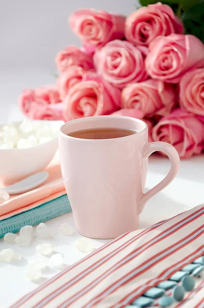 Vestido a rayas con té en la taza rosa, azúcar y ramo de rosas —  Fotos de Stock