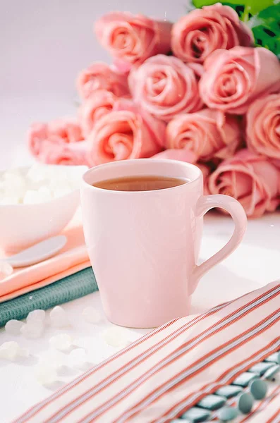 Vestido a rayas con té en la taza rosa, azúcar y ramo de rosas —  Fotos de Stock