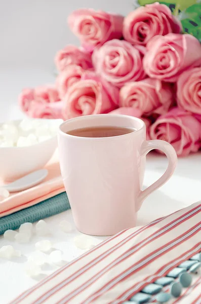 Vestido a rayas con té en la taza rosa, azúcar y ramo de rosas —  Fotos de Stock