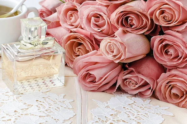 Bottiglia di profumo, gonna di design ricamata, tazza di tè e mazzo di rose — Foto Stock