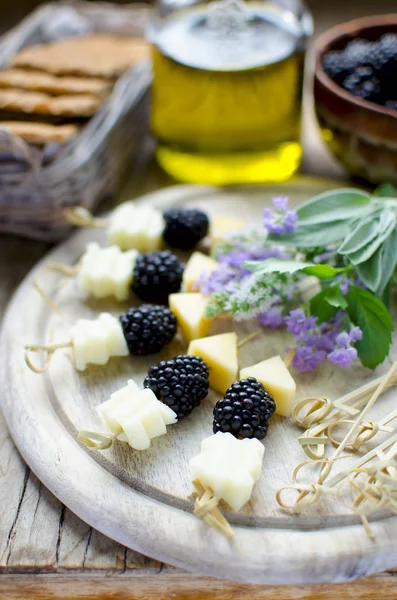 Varas de amora e queijo com ervas: lavanda, sálvia, hortelã servida na mesa de madeira vintage com azeite e pão integral — Fotografia de Stock