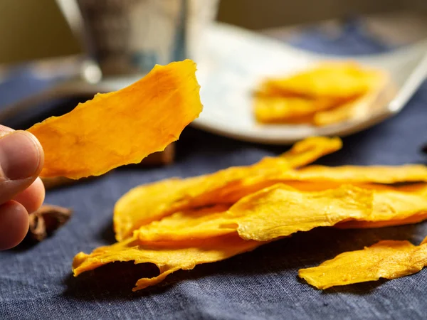 Mavi arka planda portakallı kurutulmuş mango meyvesi var. Stok Fotoğraf