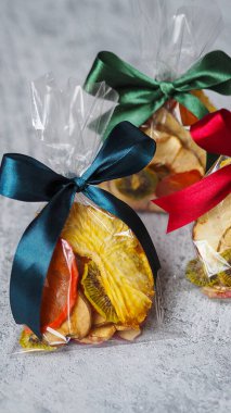 Gri arka planda küçük bir kutuya doldurulmuş kurutulmuş meyveler.