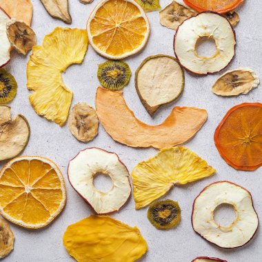 Renkli kurutulmuş meyvelerin düzleşmesi. Hurma, armut. Beyaz arka planda elma, kavun, ananas, kivi ve portakal.