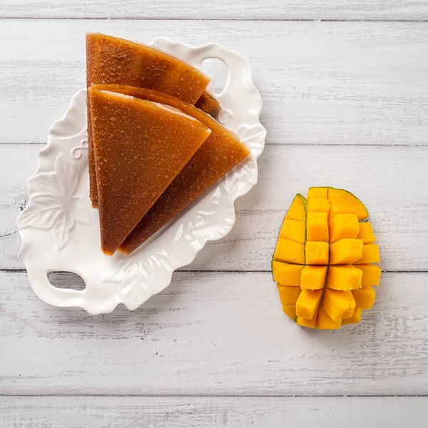 Свежий манго и фруктовая кожа лежали на белой тарелке — стоковое фото