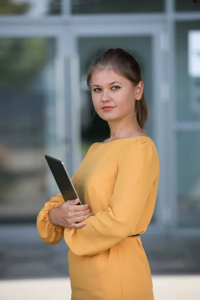 Jonge zakenvrouw in gele jurk — Stockfoto