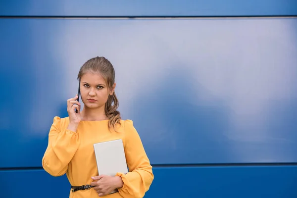 Usměvavá mladá podnikatelka na telefonu drží tablet — Stock fotografie