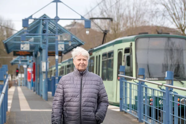 Äldre kvinna och spårvagnshållplatsen — Stockfoto