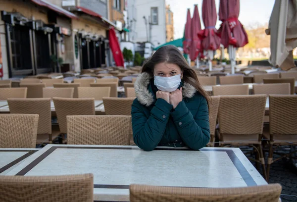 Σοβαρή Νεαρή Γυναίκα Προστατευτική Μάσκα Που Κάθεται Έξω Στην Άδεια Εικόνα Αρχείου