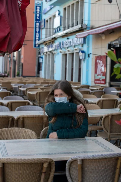 Grave Giovane Donna Con Maschera Protettiva Seduta All Aperto Sulla Foto Stock