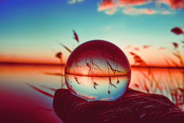 Etrafında uzun yeşillikli bir gölün yaratıcı kristal lens topu fotoğrafçılığı