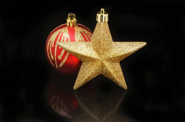Estrela de Natal e bugiganga contra preto — Fotografia de Stock