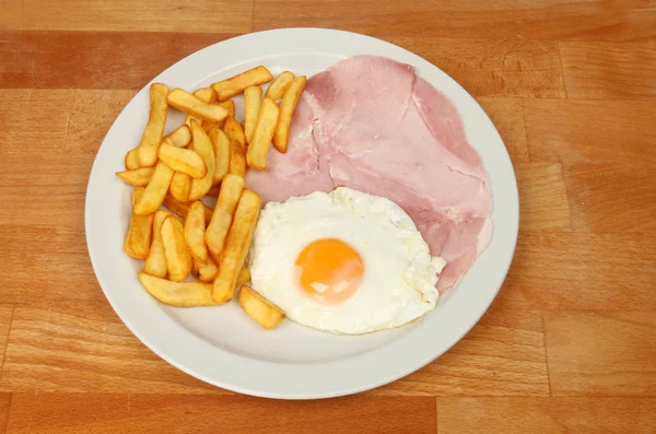 火腿蛋和薯片放在木桌上的盘子上 — 图库照片
