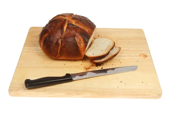 スライス カット白に対して分離された木製のまな板にパン切りナイフと無愛想なパンを焼き — ストック写真