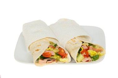 Pastırma, marul ve domatesli sandviç. Yanında da beyaz bir tabakta peçete.