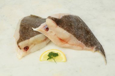Misket tahtasında limon ve maydanozla süslenmiş Brill Fish pirzolası.