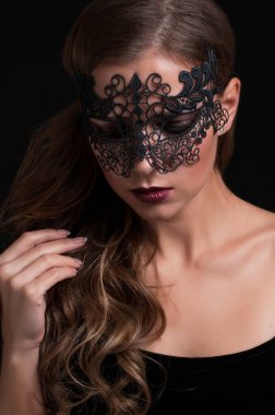 Venedik dantelli maskeli güzel esmer kadın. Dantelli portre maskesini kapat. Kırmızı dudaklar makyaj yapar. Siyah arkaplanda erotik tutkulu kadın görüntüsü
